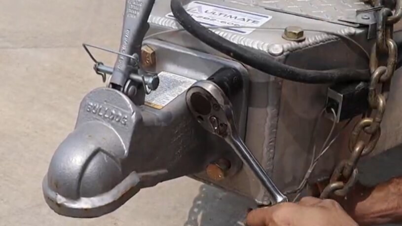 Existing ball coupler on a trailer square mounting plate before removal