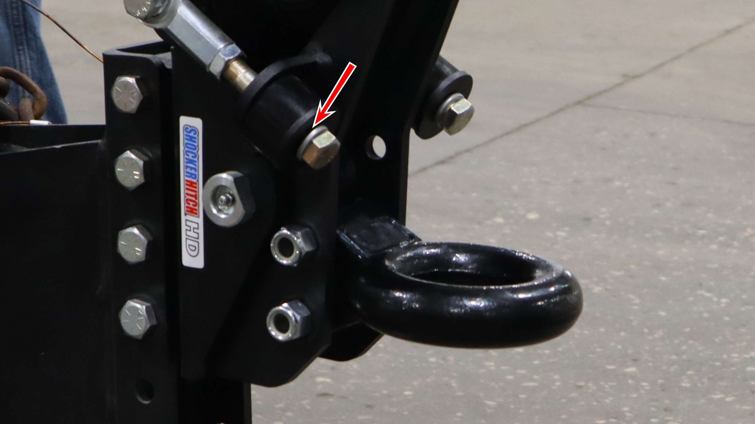 Arrow pointing to the top of the washer between the bolt head and bump cushion on a Shocker Air Tongue Mount
